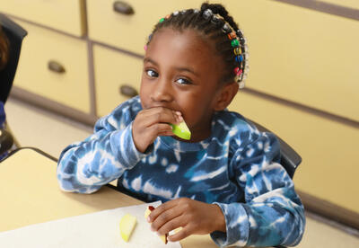 Student takes a bite of apple