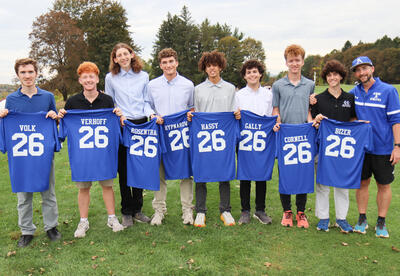 Senior boys' cross country runners showing off their senior t-shirts with Coach Wehle