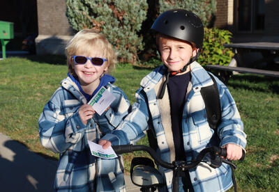 Three students on scooters meet up in front of school
