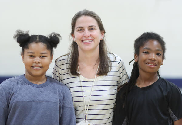 Anne Conboy posing for a photo with two students
