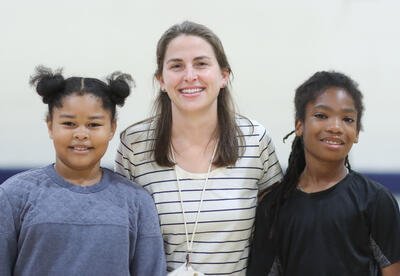 Anne Conboy posing for a photo with two students