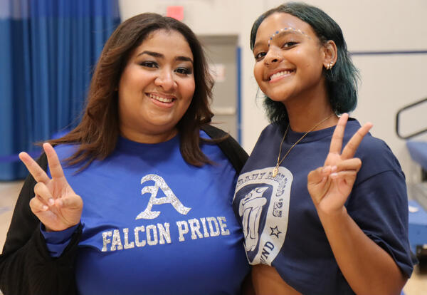 Staff member and student wearing Falcon gear at pep rally