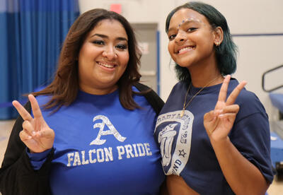 Staff member and student wearing Falcon gear at pep rally