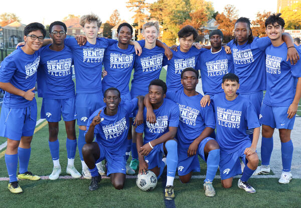 Seniors on boys' soccer team posing together on the turf