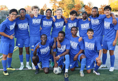 Seniors on boys' soccer team posing together on the turf