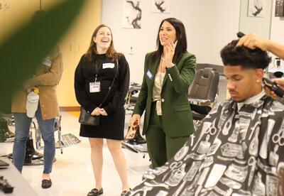 Tour group observing a barbering student perform a haircut