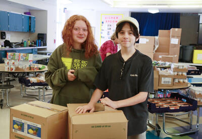 鶹Ӱ High students packing food bags at Pine Hills Elementary School