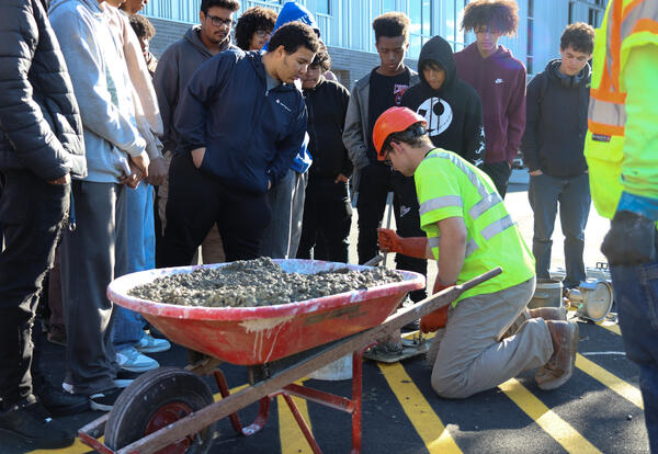 Students watch an industry professional performing field tests