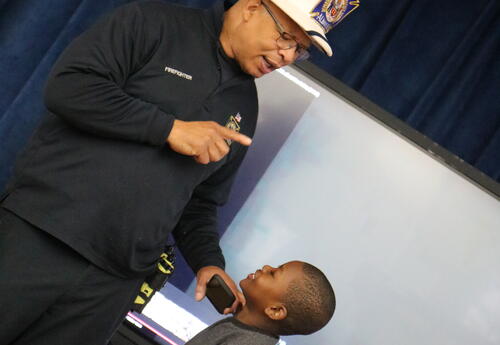 A firefighter teaches students about fire prevention and safety.