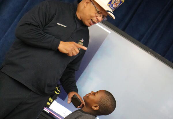 A firefighter teaches students about fire prevention and safety.