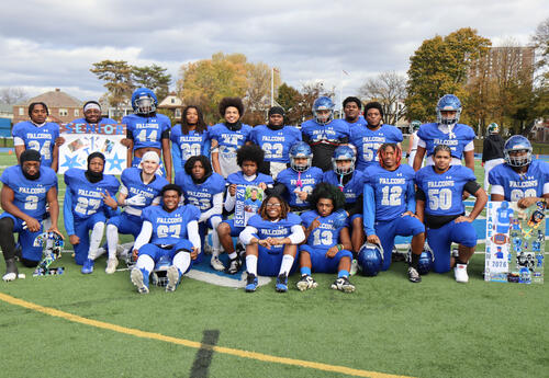 Seniors on football team posing together on the field