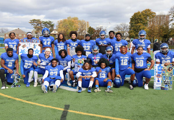 Seniors on football team posing together on the field