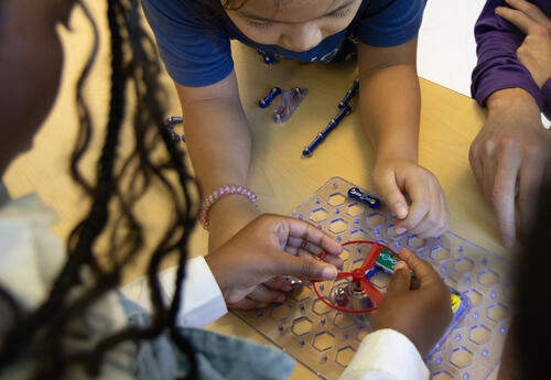 Student hands operate a circuit