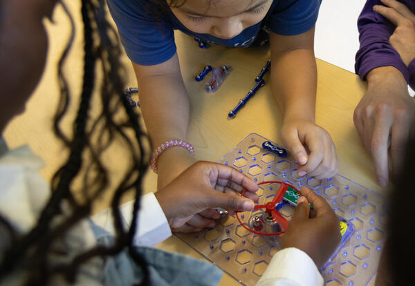 Student hands operate a circuit