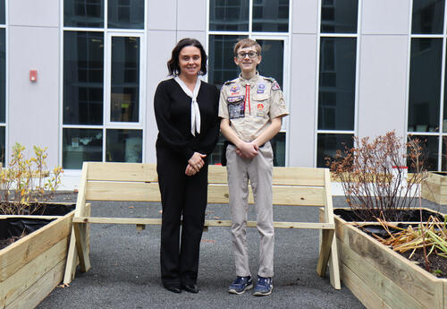 Roberts standing with Principal Commerford next to the benches and planters in the courtyard