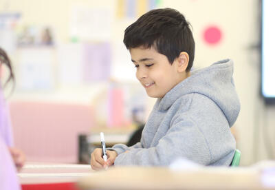Student smiling while working on an assignment