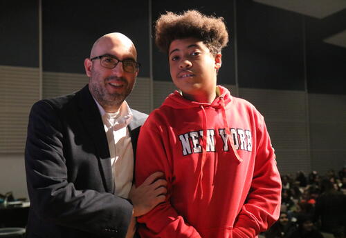 The principal of Myers congratulates a student during honor roll.