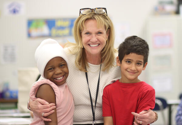 Teacher and two students smiling and posing for a photo