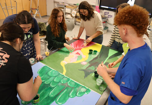 Photo of students working on the artwork at Albany High