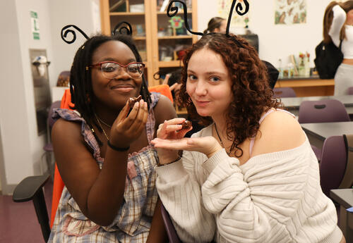 Two students holding brownies baked with crickets