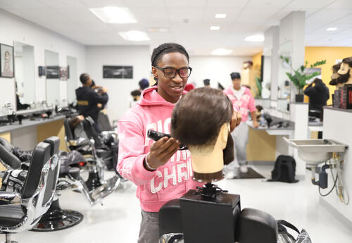 Barbering student cutting hair