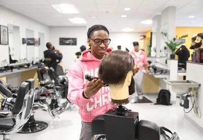 Barbering student cutting hair