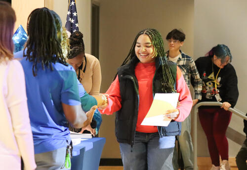 A student accepts her honor roll certificate.