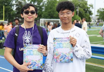 Seniors posing with 2025 yearbook