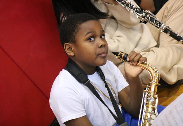 A students warms up on his saxophone before a concert.