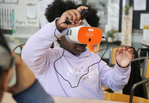 A students uses VR goggles in Social Studies.