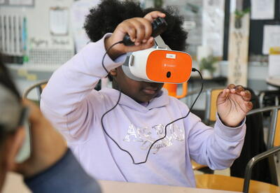 A students uses VR goggles in Social Studies.