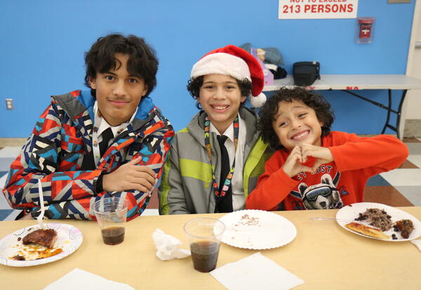 Three students enjoy a meal at Myers' holiday party.