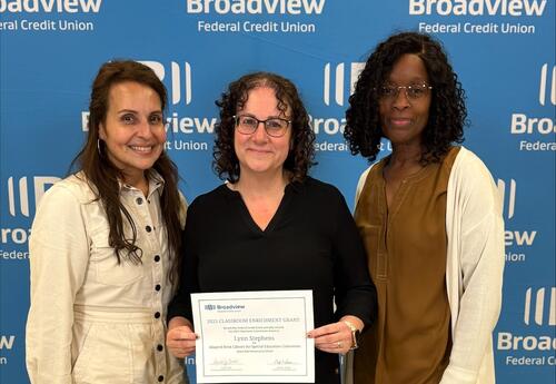 A teacher and two administrators accepting a grant.