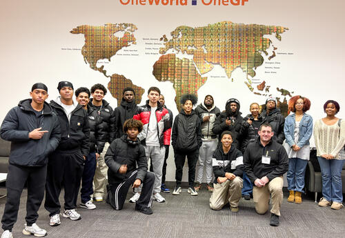 Group photo during the field trip in front of a mural of the globe
