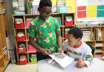 Two students work on a holiday craft together.