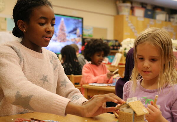 Two students put together a graham cracker holiday house.