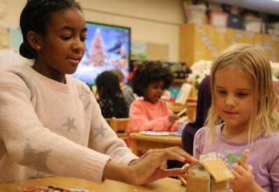 Two students put together a graham cracker holiday house.