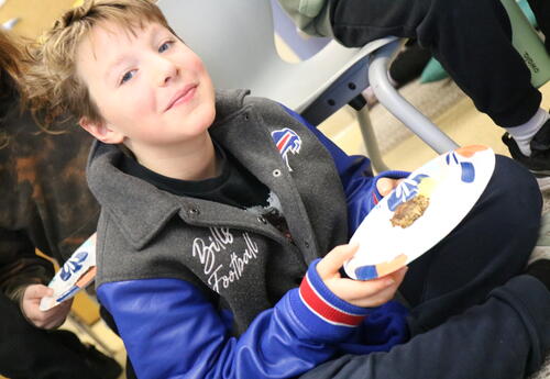 A students eats a latke during a Hanukkah celebration.