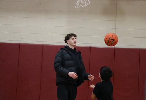 A Siena basketball player works with a North Albany Middle School student.