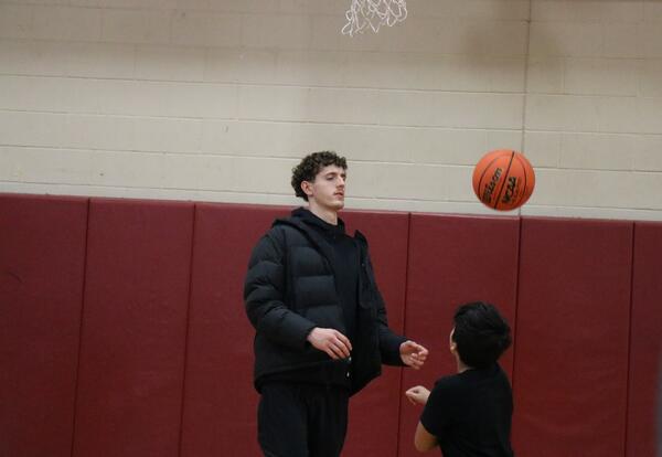 A Siena basketball player works with a North Albany Middle School student.