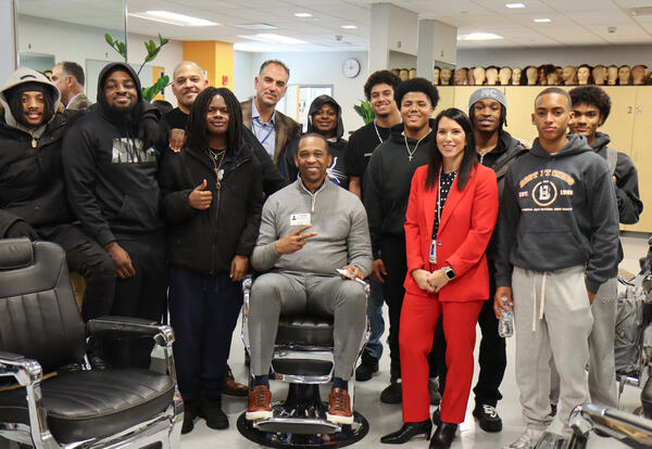 Barbering students and NYS Secretary of State posing for a group photo