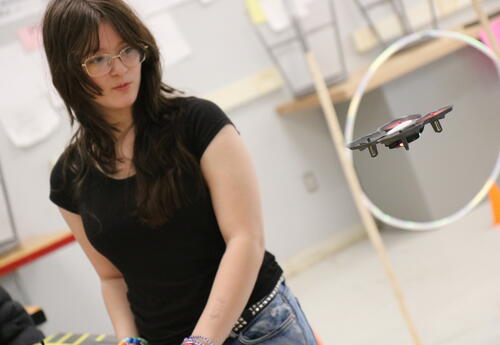 A student observes a programmable drone in class.
