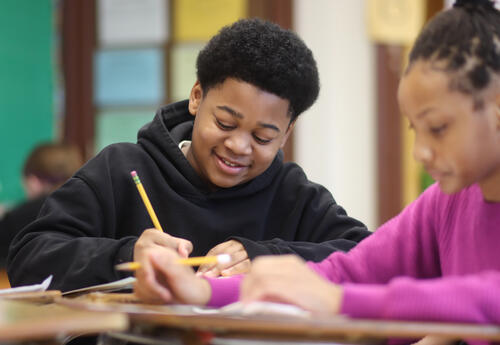 Student smiling while working on an assignment