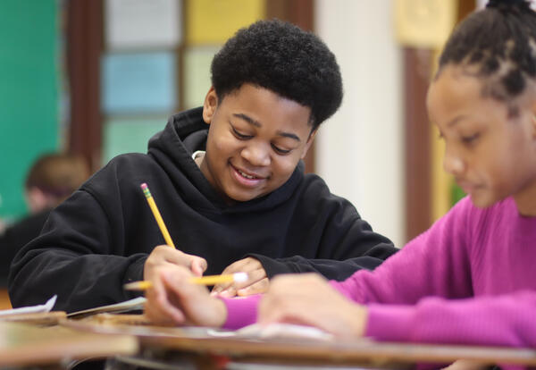 Student smiling while working on an assignment