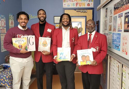 Fraternity members posing with books