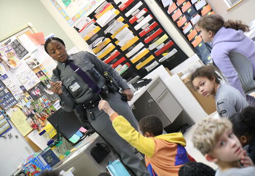 A member of the New York State Police meets with students.