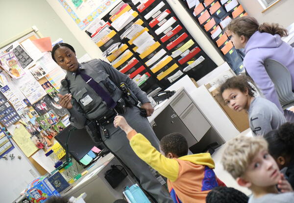 A member of the New York State Police meets with students.