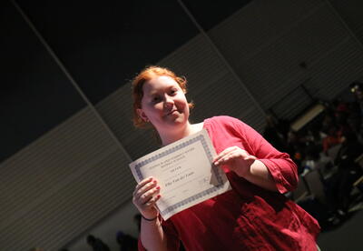 A student displayers her honor roll certificate.