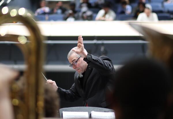 John Halvorsen directing music at a concert at Albany High