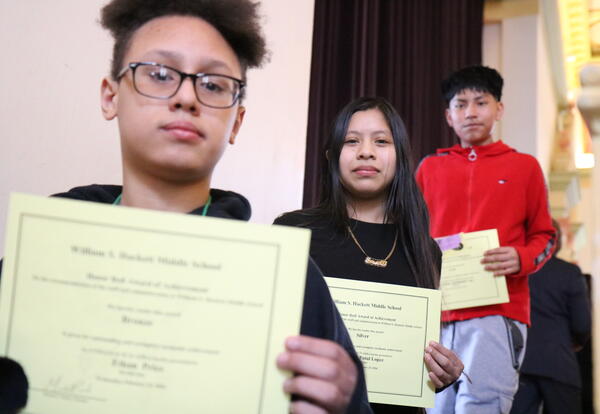 Three students pose with their honor roll certificates.